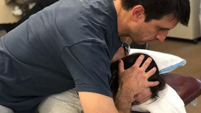 A BreakThrough Physical Therapist helps a patient with neck pain.