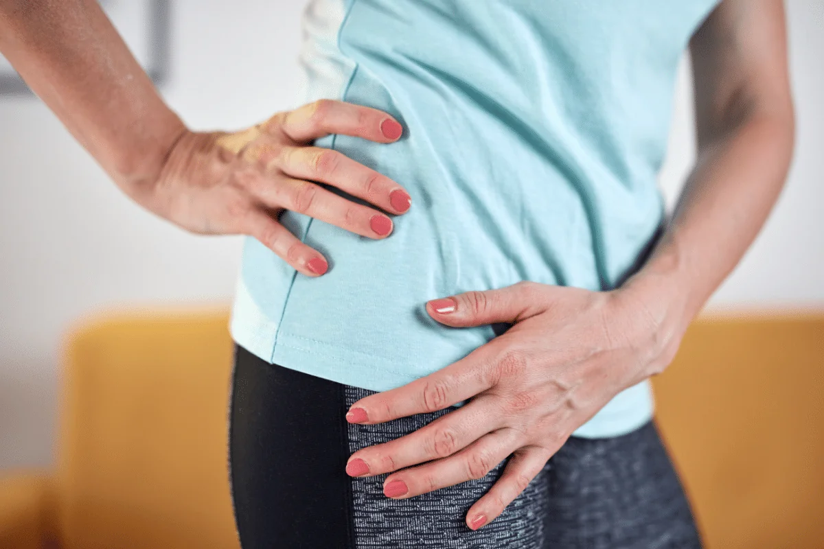 photo of a woman holding her hip in pain